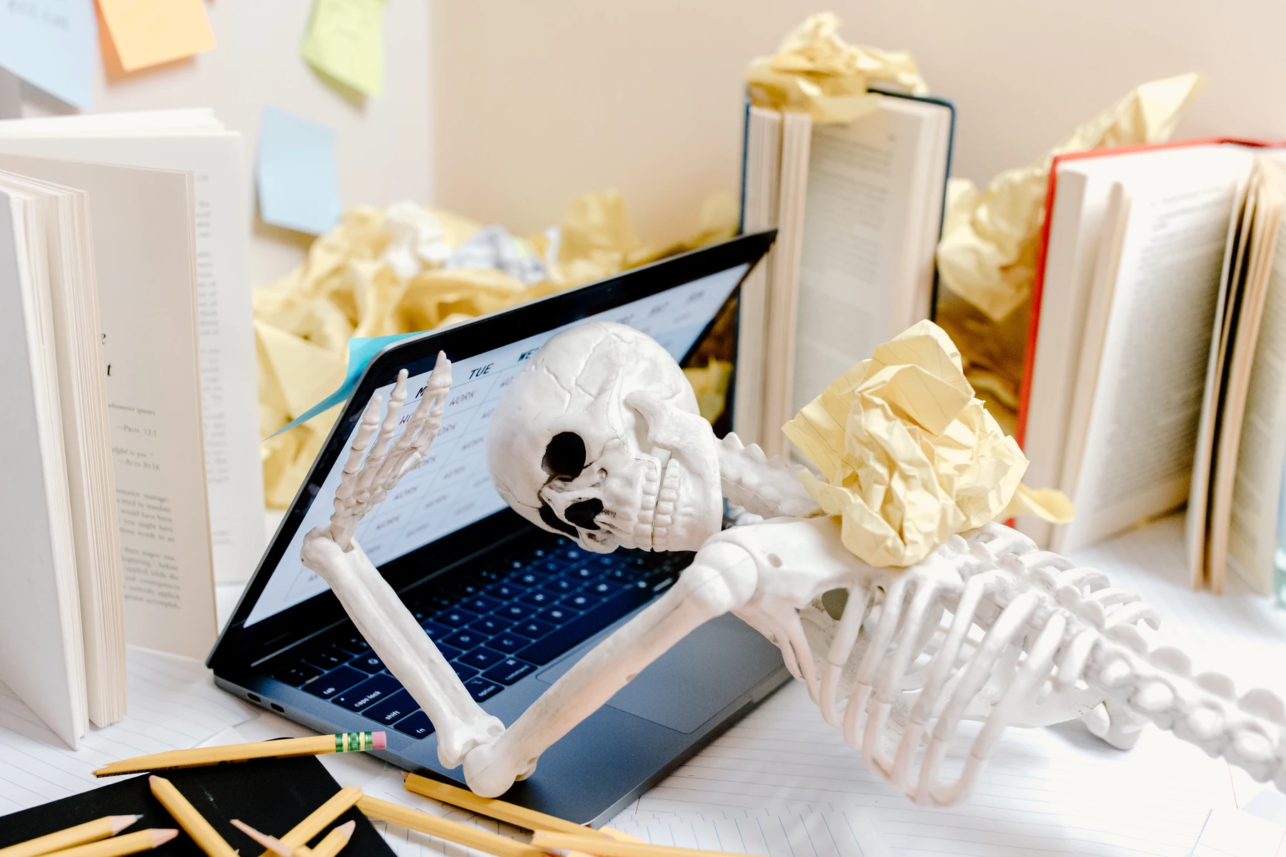A skeleton lying on a laptop after suffering workplace burnout