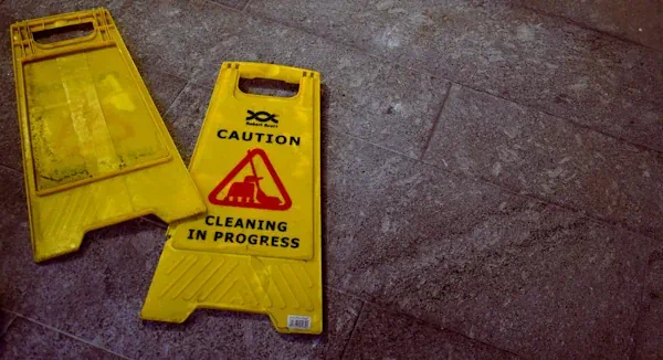 A photo of a broken wet floor sign lying on the ground
